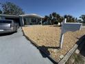 Charming home featuring rock landscaping, a gray driveway, and a white mailbox at 2344 Tahitian Dr, Holiday, FL 34691