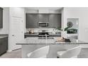 Modern kitchen with granite countertops, stainless steel appliances, and a breakfast bar with seating at 2497 Orange Harvest Pl, Seffner, FL 33584