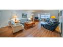 Cozy living room featuring hardwood floors, comfortable seating, and plenty of natural light at 2720 Lancaster Dr, Sun City Center, FL 33573