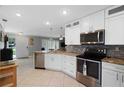 Bright kitchen featuring white cabinetry, stainless appliances, granite countertops, and mosaic backsplash at 3059 Hickory Dr, Largo, FL 33770