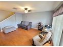 Open-concept living room with hardwood floors, comfortable seating, and a work space by the window at 310 Kensington Lake Cir, Brandon, FL 33511