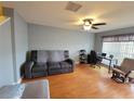 Spacious living room with a ceiling fan, hardwood floors, sofa, and desk workstation at 310 Kensington Lake Cir, Brandon, FL 33511