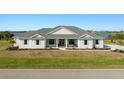 Inviting single-story home with charming shutters, a welcoming front porch, and manicured lawn at 3319 Gulf City Rd, Ruskin, FL 33570
