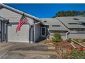 Charming townhouse with attached garage featuring well-maintained landscaping and an American flag near the front entrance at 39650 Us Highway 19 N # 1422, Tarpon Springs, FL 34689