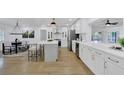 Bright, open-concept kitchen with white cabinetry, stainless appliances, and spacious countertops, flowing into the dining area at 5426 Creeping Hammock Dr, Sarasota, FL 34231