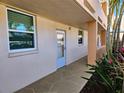 Exterior view of the condo featuring a sidewalk and covered entry and well maintained landscaping at 7560 Bay Island S Dr # 144, South Pasadena, FL 33707