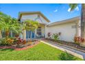 Inviting home featuring lush landscaping, a walkway, and chairs on the front porch at 10720 Rockledge View Dr, Riverview, FL 33579