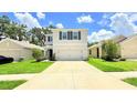 Charming two-story home with neutral stucco, dark shutters, two car garage, and well-manicured landscaping at 10908 Carlton Fields Dr, Riverview, FL 33579