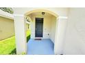 Inviting arched front porch with painted floor and welcome mat offers a warm entry at 10908 Carlton Fields Dr, Riverview, FL 33579