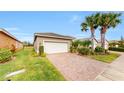 Attached two-car garage with a paved driveway and landscaped front yard, offering convenience and curb appeal at 15644 Aurora Lake Cir, Wimauma, FL 33598