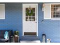 Inviting front door with a wreath, set against a blue brick wall with white trim at 16410 Lake Byrd Dr, Tampa, FL 33618