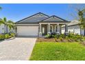 Charming single-story home showcasing a manicured lawn, stone accents, and a welcoming front porch at 17441 Savory Mist Cir, Bradenton, FL 34211