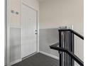 Apartment door featuring neutral paint, and a black railing on a staircase at 209 Seahorse Se Dr # D, St Petersburg, FL 33705