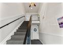 Carpeted staircase with black railing, leading to the upper level of the home at 209 Seahorse Se Dr # D, St Petersburg, FL 33705