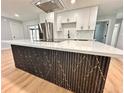 Modern kitchen featuring a sleek island with unique gold vein decor, stainless steel appliances, and ample cabinet space at 2602 Surrey Dr, Palm Harbor, FL 34684
