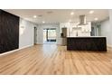 Bright open living space features wood floors, modern wall decor, and connects to a kitchen with stainless steel appliances at 2602 Surrey Dr, Palm Harbor, FL 34684
