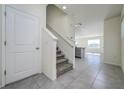 Inviting foyer featuring tiled floors, a staircase, and an open view to the living area at 30910 Penny Surf Loop, Wesley Chapel, FL 33545