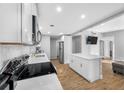 Well-lit kitchen featuring white cabinets, a center island, stainless steel appliances, and open layout at 3104 Bay St, Sarasota, FL 34237