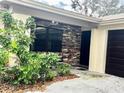 Close-up of front entrance with stone detail, updated window and dark door at 3608 Oak Bark Ln, Brandon, FL 33511