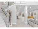 Elegant home foyer featuring a glass-railed staircase, marble floors, and a decorative sculpture at 375 Wellington Ave, Oldsmar, FL 34677