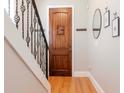 Hallway view featuring hardwood floors, a staircase with a metal railing, and neutral paint at 418 S Habana Ave, Tampa, FL 33609