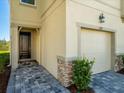 Close-up exterior view of home with a one-car garage, brick accents, and a covered entry at 4272 Cloud Hopper Way, Lutz, FL 33559