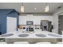 Spacious kitchen featuring an island, white cabinetry, stainless steel appliances, and stylish backsplash at 4272 Cloud Hopper Way, Lutz, FL 33559