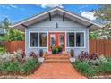 Home featuring a brick walkway, complemented by green shrubbery, leading to a vibrant red front door at 436 12Th Ne Ave, St Petersburg, FL 33701