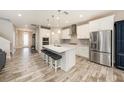 Modern kitchen with white cabinetry, stainless steel appliances, and a large center island with seating at 4607 Ballantrae Boulevard, Land O Lakes, FL 34638