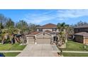 Charming two-story home with a spacious driveway and a three car garage, with nice landscaping at 5843 Justicia Loop, Land O Lakes, FL 34639