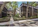 Exterior view of the condo building with trees, walkway, and reserved parking; serene community setting at 11706 Raintree Village Blvd # D, Temple Terrace, FL 33617