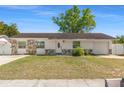 Charming single-story home featuring stone accents, a well-manicured lawn, and an attached garage at 1214 Windsor Cir, Brandon, FL 33510
