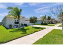 Beautiful home with a lush lawn, sidewalk and landscaped garden bed with flowers and palm trees at 1615 Redmond Brook Ln, Ruskin, FL 33570