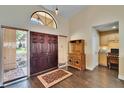 Inviting foyer with wood-look tile flooring, an arched window, and a decorative hutch at 1802 Hitching Post Pl, Plant City, FL 33566