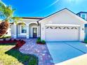 Beautiful exterior featuring a two-car garage, brick walkway, and manicured lawn at 1945 Fruitridge St, Brandon, FL 33510