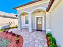 Inviting front porch with a brick walkway, columns, and a decorative front door at 1945 Fruitridge St, Brandon, FL 33510