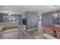 Open-concept living room and dining area with hardwood floors and sliding glass doors at 2988 Pinewood Run, Palm Harbor, FL 34684