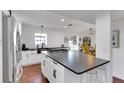 Modern kitchen features a large island with dark countertops, white cabinetry, and stainless steel appliances at 355 21St Ne Ave, St Petersburg, FL 33704