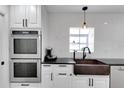 Kitchen showcases a stainless steel oven, farmhouse sink, and white cabinets with black hardware at 355 21St Ne Ave, St Petersburg, FL 33704