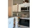 Modern kitchen with stainless steel oven, pull-out spice rack, and granite countertops at 3911 La Costa Ln, Largo, FL 33771