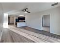 Open-concept living room with wood-look floors, ceiling fan, and access to the kitchen at 4719 Lindever Ln, Palmetto, FL 34221