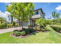 Charming two-story home with a paved driveway and a well-manicured lawn with lush landscaping at 4849 Isola Ct, Wesley Chapel, FL 33543