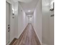 Clean, well-lit hallway with wood flooring and modern sconces, leading to various unit entrances at 600 3Rd S Ave # 207, St Petersburg, FL 33701