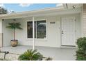 Inviting front entrance features a decorative palm tree and contemporary door with modern hardware at 7740 Bracken Dr, Port Richey, FL 34668
