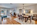 Open-concept dining room featuring wood floors, modern chandelier, and neutral decor with lots of space at 8942 Aberdeen Creek Cir, Riverview, FL 33569