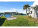 Backyard with a waterfront view, lush green grass, boat dock, and landscaping at 9017 Petal Ct, Hudson, FL 34667