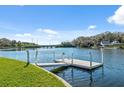 Waterfront backyard with a private dock and a serene water view on a sunny day at 9017 Petal Ct, Hudson, FL 34667