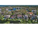 Aerial view of the home in a neighborhood with waterfront access, showcasing surrounding trees and canal at 902 Marco Ne Dr, St Petersburg, FL 33702