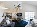 Bright living room with vaulted ceilings, a ceiling fan, and a sliding glass door to a balcony at 9730 Lake Chase Island Way # 9730, Tampa, FL 33626