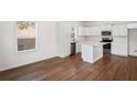 Bright kitchen with new stainless steel appliances, white cabinetry, and an island on dark hardwood floor at 1001 Newton S Ave, St Petersburg, FL 33705